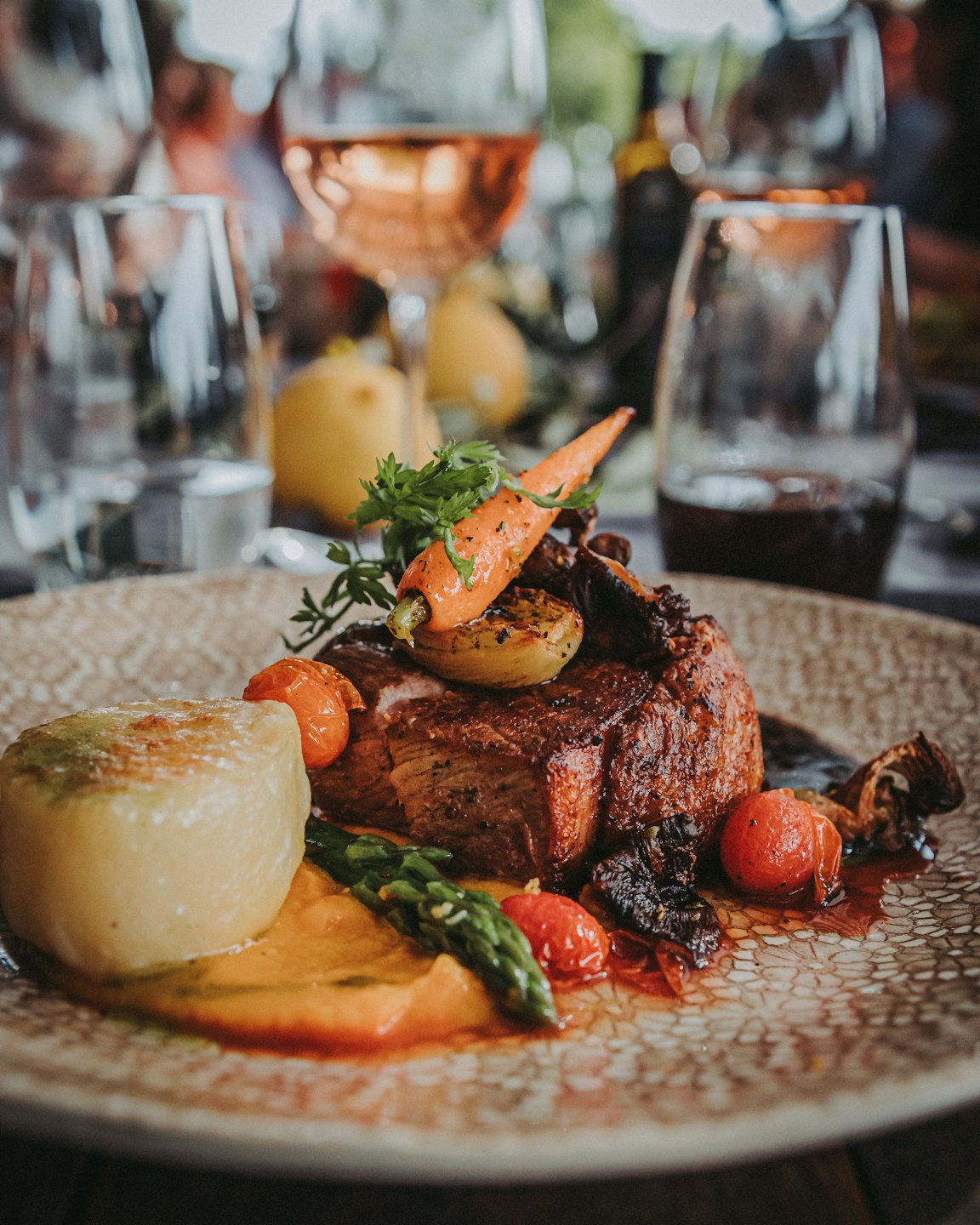 A gourmet plate of seared meat, vegetables, and creamy potatoes.