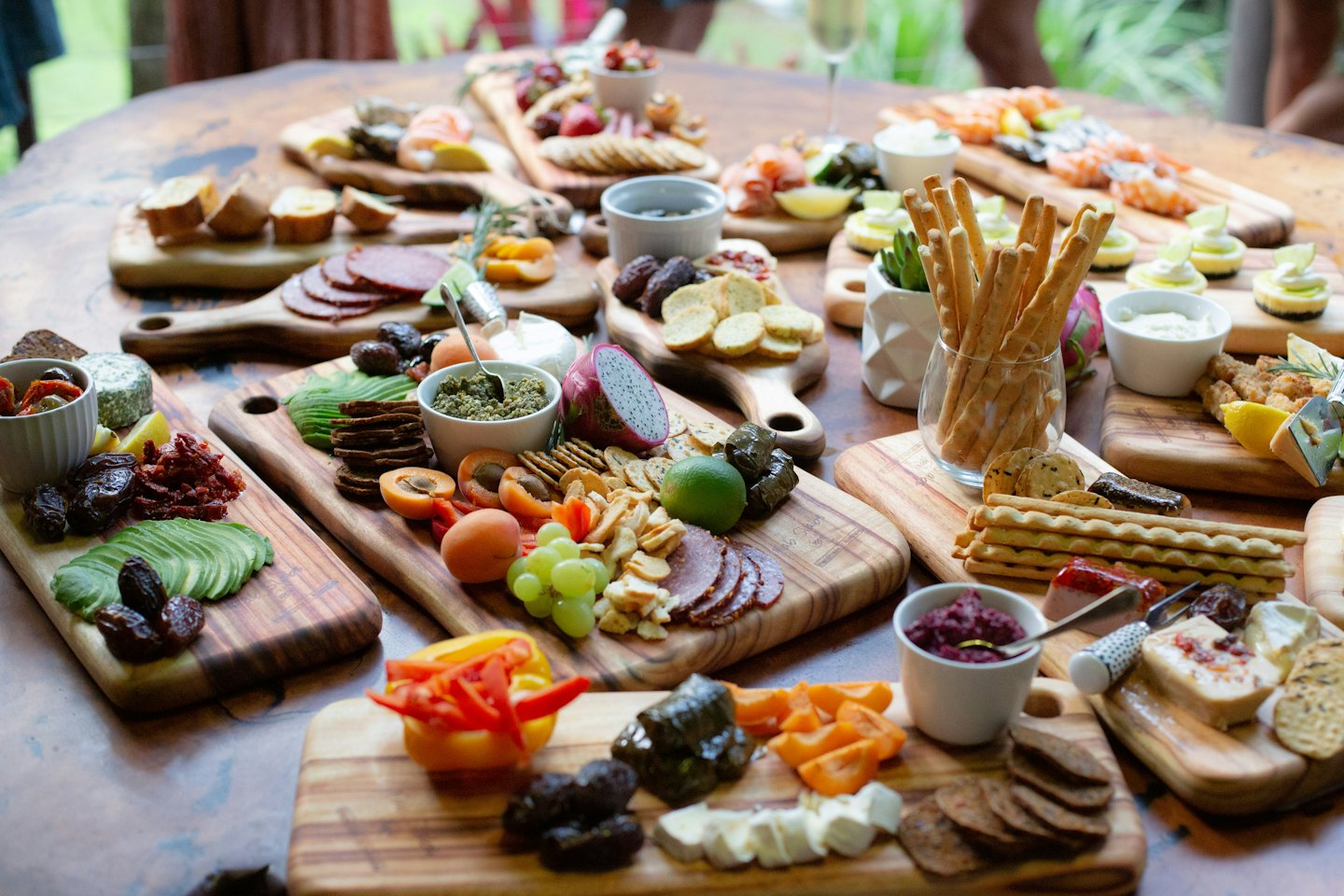 Rustic table laden with charcuterie and appetizer platters.