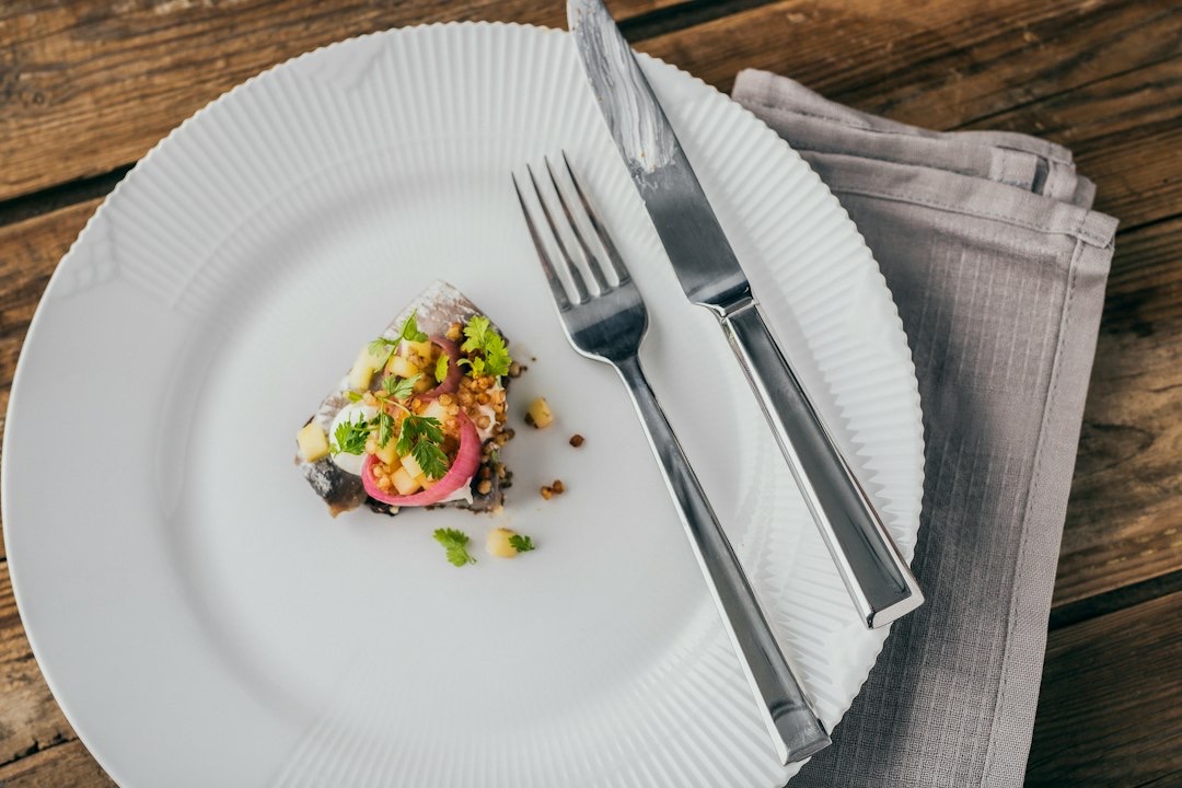Gourmet appetizer with herring and apple on a rustic table.